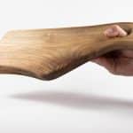 Дъска с нестандартна дръжка, хваната от мъжка ръка, за да покаже как се използва.